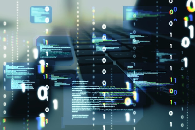 Close up of desktop with laptop and abstract coding binary code hologram on blurry background Artificial intelligence and development concept Double exposure