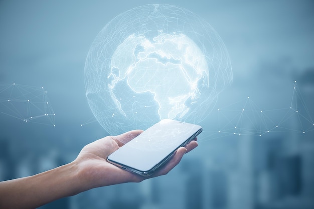 Close up of female hand holding cellphone with glowing polygonal globe on blurry city background World map and earth concept