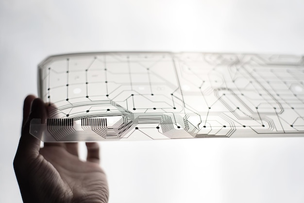 Close-up of hand holding transparent material against white background