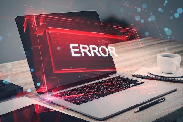 close up of laptop on desktop with coffee cup and abstract red error hologram connection and crime concept double exposure