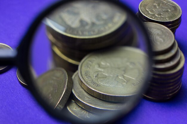 Close-up of magnifying glass over coins