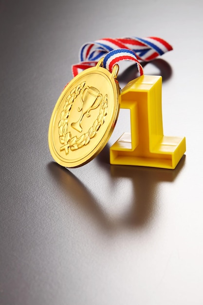 Close-up of number 1 with gold medal on gray background