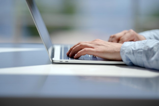 Close-up of person using laptop on table