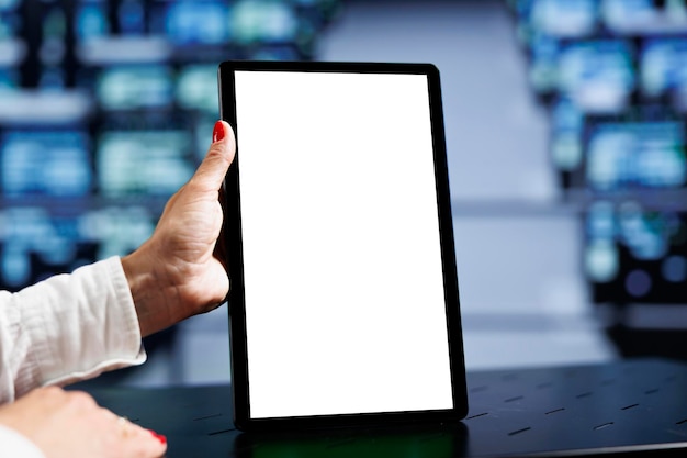 Close up shot of mock up tablet used by qualified IT programmer in data center using server rigs to deliver massive computing power, control network resources, process and store datasets