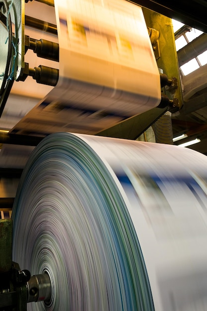 Close-up to the printed material coming out from a printing press machine