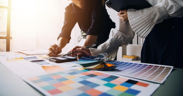 Close up ux developer and ui designer brainstorming about mobile app interface wireframe design on table with customer breif and color code at modern officeCreative digital development agency