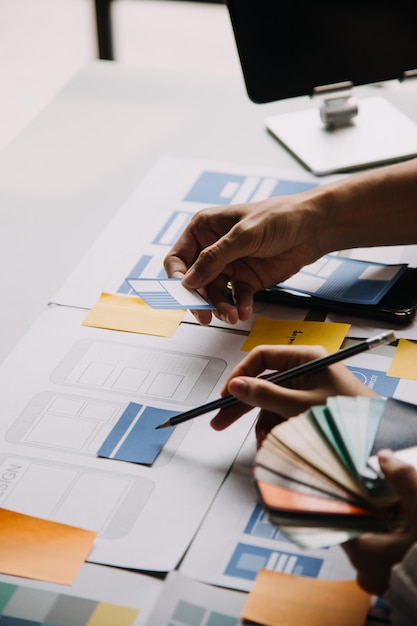 Close up ux developer and ui designer use augmented reality brainstorming about mobile app interface wireframe design on desk at modern officeCreative digital development agency