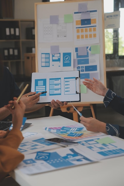 Close up ux developer and ui designer use augmented reality brainstorming about mobile app interface wireframe design on desk at modern officeCreative digital development agency