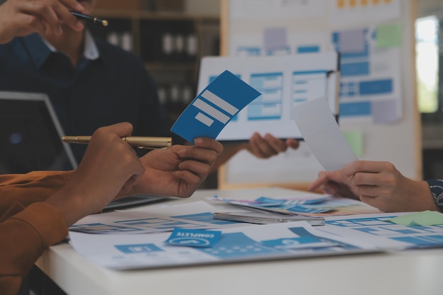 Close up ux developer and ui designer use augmented reality brainstorming about mobile app interface wireframe design on desk at modern officeCreative digital development agency