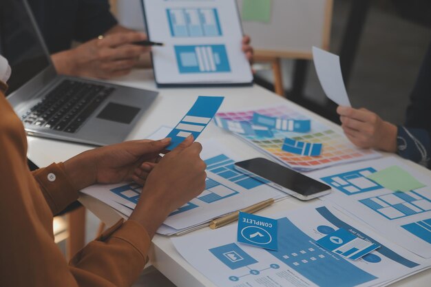 Close up ux developer and ui designer use augmented reality brainstorming about mobile app interface wireframe design on desk at modern officeCreative digital development agency