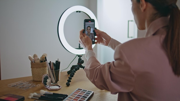 Closeup influencer adjusting smartphone tripod at home online learning concept