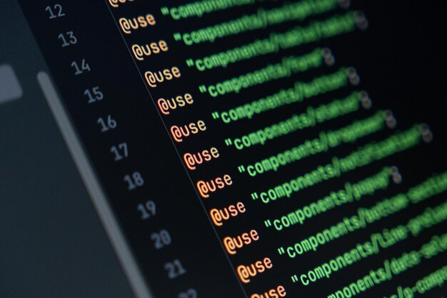closeup of computer screen with colorful sass code focus on use directive web development and frontend programming