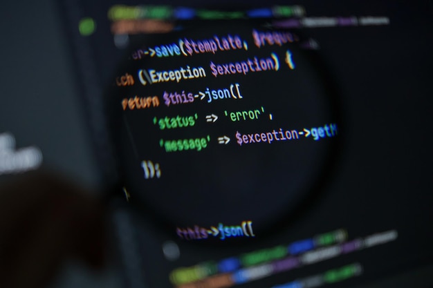 closeup of php code showing error handling with json response under magnifying glass on dark screen background in development environment