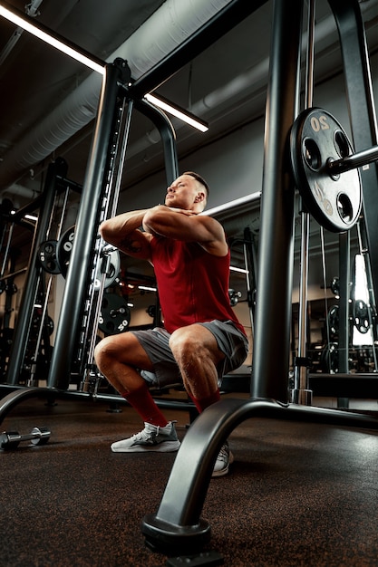 closeup portrait of a muscular man workout with barbell at gym. brutal bodybuilder athletic man with six pack, perfect abs, shoulders, biceps, triceps and chest.