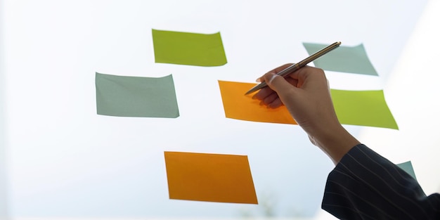Colleagues sharing insights while arranging sticky notes for project planning and analysis