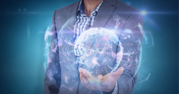 Composition of network of connections with glowing globe over hand of businessman