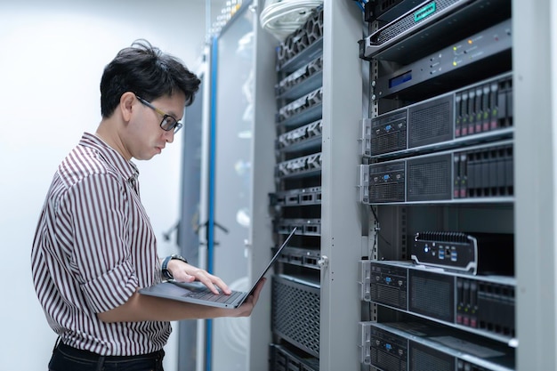 computer engineer is setting up network in server roomsystems maintenance technicianmale engineer working in server room at modern data center