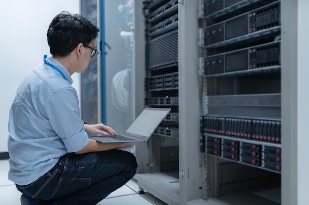computer engineer is setting up network in server roomsystems maintenance technicianmale engineer working in server room at modern data center