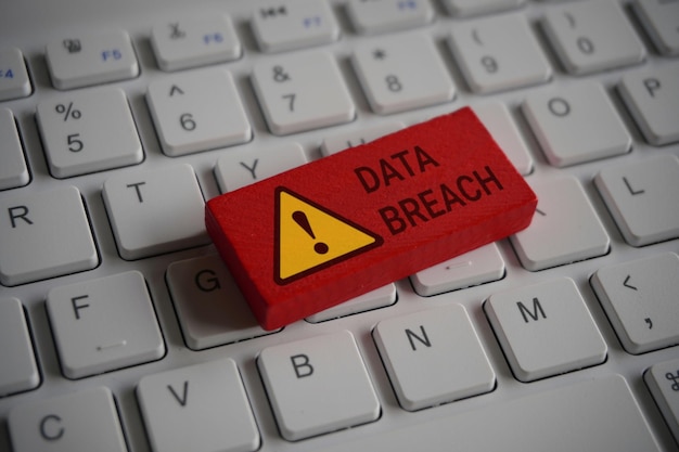 Computer keyboard and red wooden cube with text DATA BREACH Internet technology and network concept