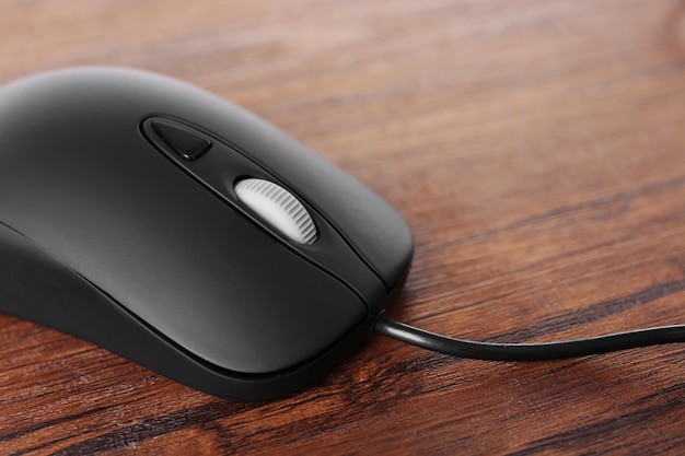 Computer mouse with cord on wooden background