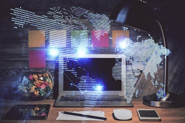 Computer on desktop with social network hologram Double exposure Concept of international people connections