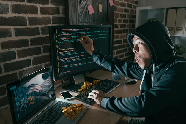 computer programmer man using bad data virus hacking all business trading system and getting many bitcoin ransom feeling excited.