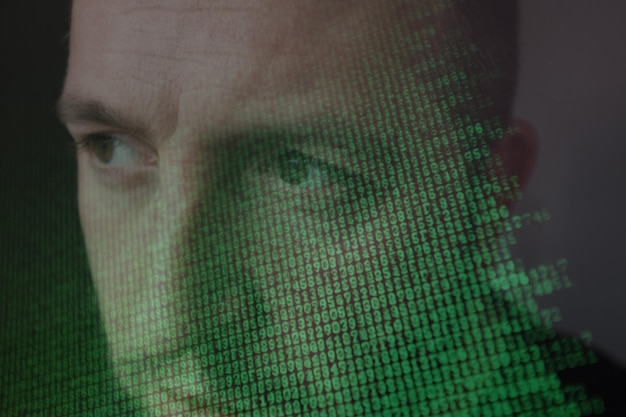 Computer screen with binary code over mans face