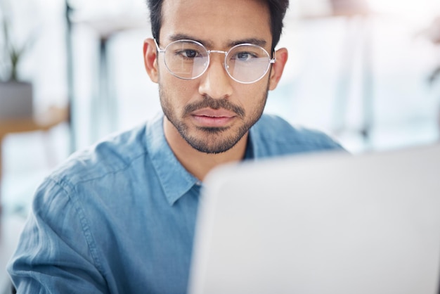 Contemplating computer and business man in office for idea research serious and planning Website technology and digital with male employee reading online for proposal project and email news