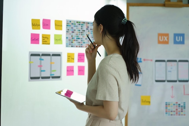 Creative ux designer brainstorming designing screens for mobile responsive website development with UI UX Developing wireframe sketch layout design mockup on smartphone screen