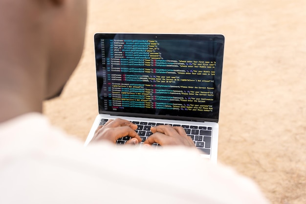 Crop African American man creating computer software