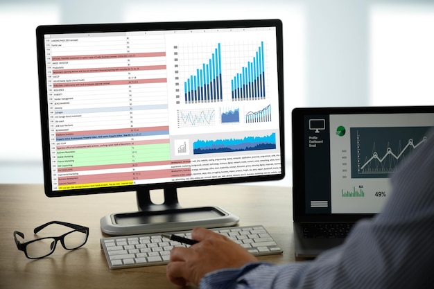 Cropped hand of businessman analyzing data on desk in office