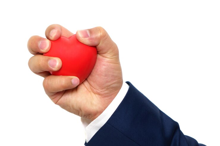 Kuva cropped hand of businessman holding heart shape against white background