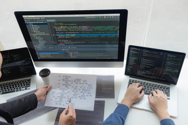 Cropped hand of computer programmers brainstorming in office