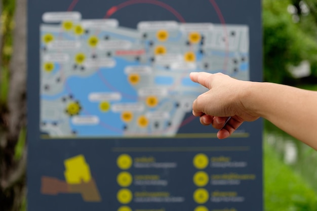 Cropped hand of person pointing at information sign