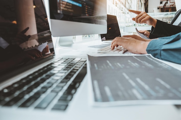 cropped hands of business people using computers on desk