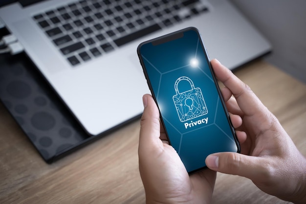 Cropped hands of man holding mobile phone with privacy text on screen