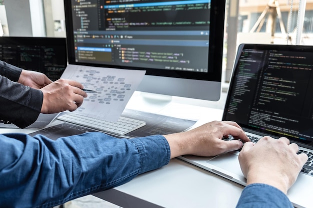 cropped hands of people discussing over computer on table