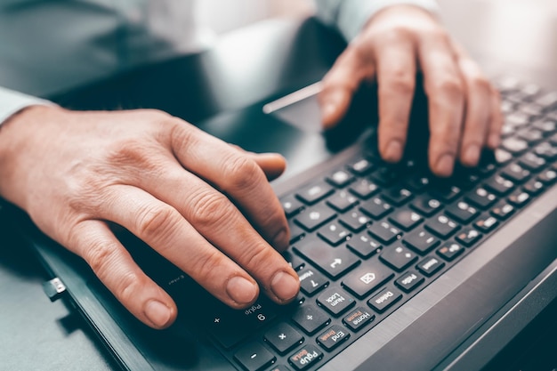 Cropped hands using laptop