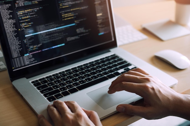 Cropped image of person using laptop on table