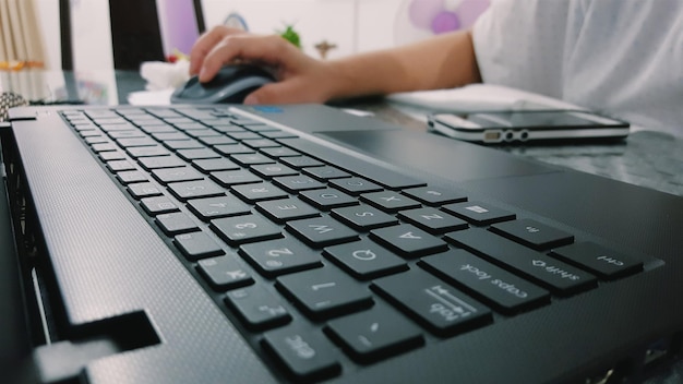 Cropped image of person using laptop