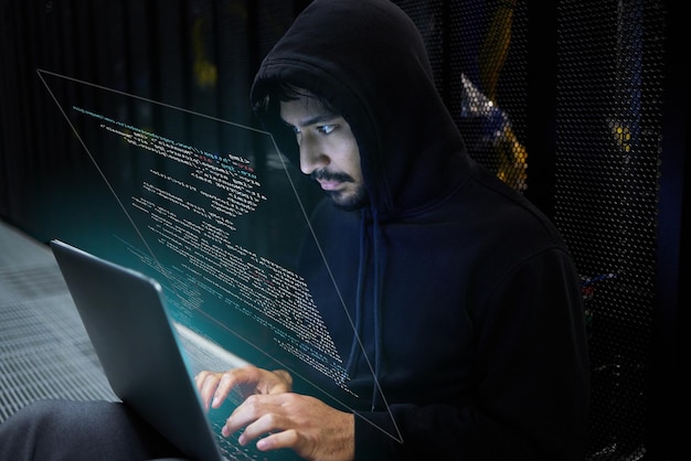 cyber security coding and hacker in server room with hologram laptop in data center and stealing sensitive digital information technology software and man hacking in database to update ransomware