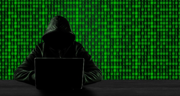 Cybercrime hacking and technology crime concept No face hacker with laptop with binary code background