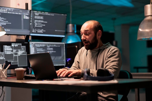 Database admin feeling happy about coding victory, celebrating development achievement in office. Pleased cheerful programmer enjoying success and win, programming html code late at night.