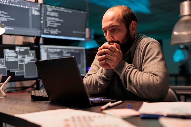 Developer feeling cold and drinking cup of coffee, using hot beverage to get warm in office late at night. Male coder serving caffeine refreshment and programming new user interface.