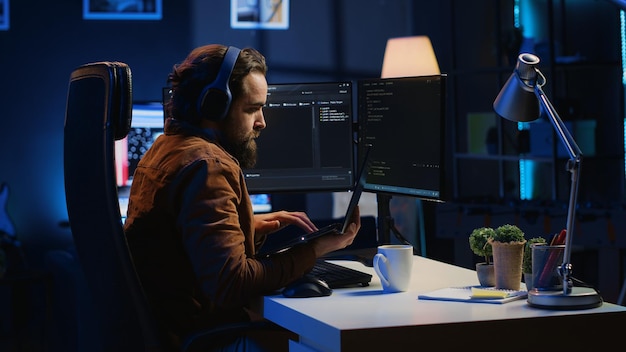 Developer typing complex code in neon lit home office listening music