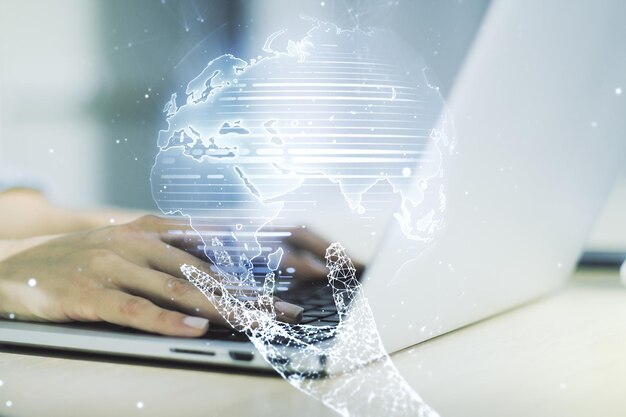 double exposure of abstract digital world map and hand typing on laptop on background research and strategy concept