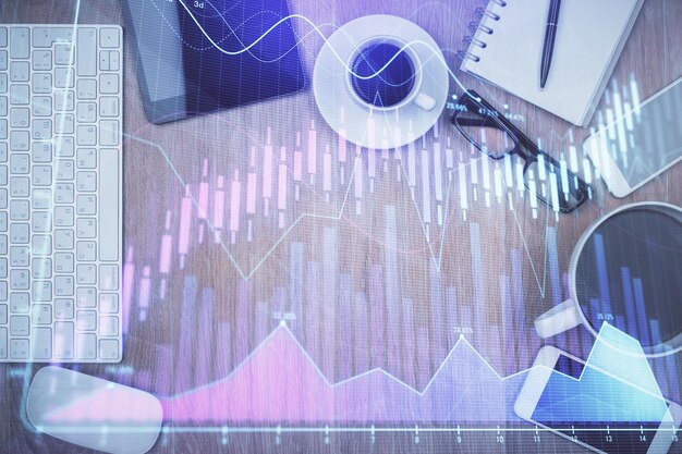 double exposure of financial chart hologram over desktop with phone top view mobile trade platform concept