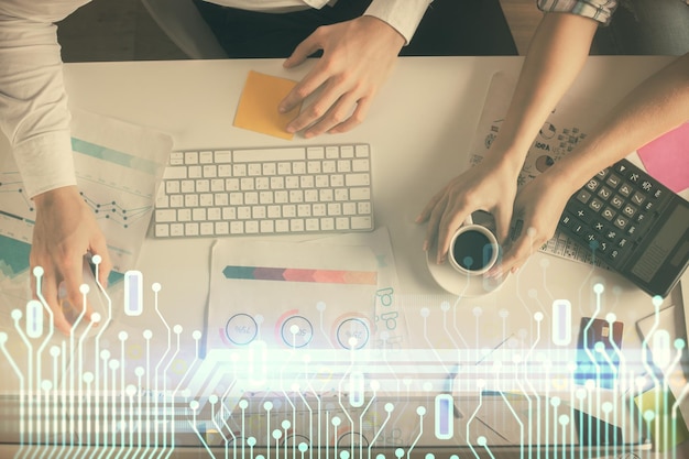Double exposure of man and woman working together and data theme hologram drawing Computer background Top View
