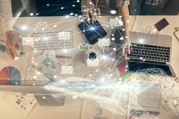 Double exposure of man and woman working together and envelop hologram drawing email concept Computer background