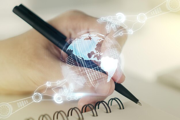 Double exposure of robotics technology with world map hologram and man hand writing in notebook on background Research and development software concept